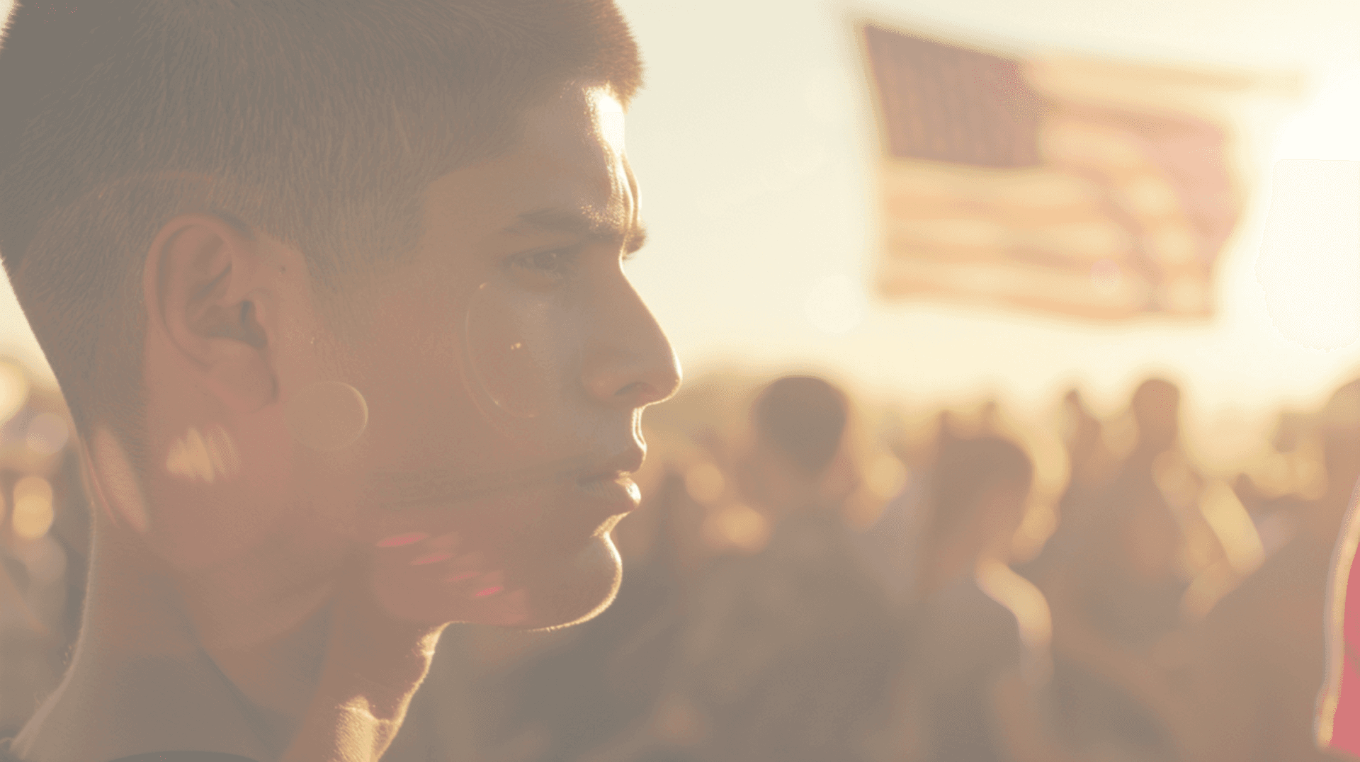 Young American at a rally with flag in the background